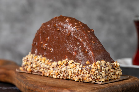 Banana and chocolate cream cake. Chocolate covered and hazelnut malaga cake on a dark background....