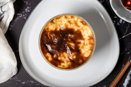 Rice pudding on a dark background. Rice pudding dessert made with milk. Turkish cuisine delicacies. Local name rice pudding. Top viewの写真素材