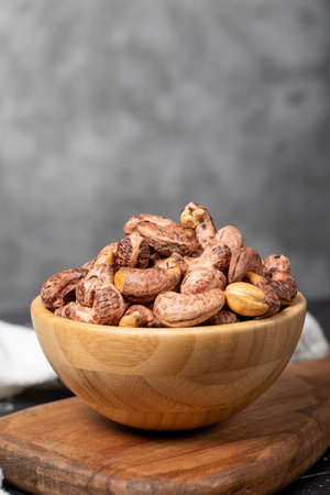 cashew nuts Roasted cashew nuts with shell in wooden bowl. superfood. Vegetarian food concept....