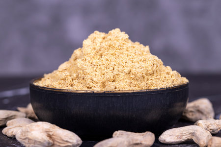Ginger powder on dark background. Powdered dried ginger in bowl