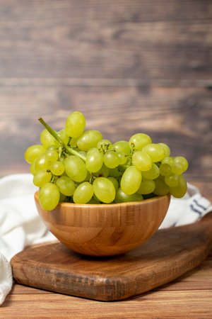 Green grapes in bowl. Organic farm products. Fresh bunch of grapes on wooden backgroundの写真素材