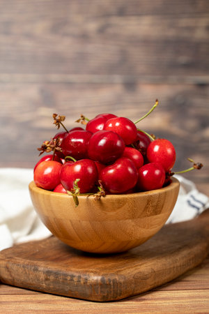 Cherry in bowl. Organic farm products. Fresh cherry on wooden background. close upの写真素材