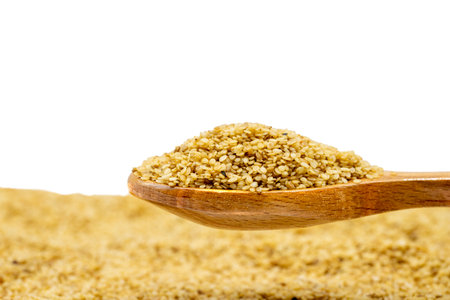 Sesame on wooden spoon. Sesame seeds isolated on a white background. close upの写真素材