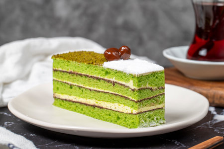 Mini slice colorful green pistachio cake. Delicious cream cake on dark background. close upの写真素材