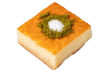 Revani dessert. Sweet semolina cake with pistachio. Ramadan sweets. Traditional Turkish cuisine delicacies. Revani dessert with syrup isolated on white background. close upの写真素材