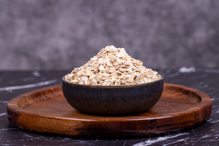 Oatmeal or Oat flakes on wooden background. Oatmeal in bowl