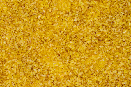 Pile of raw bulgur wheat as background, legumes as background. close-up uncooked dry bulgur wheat