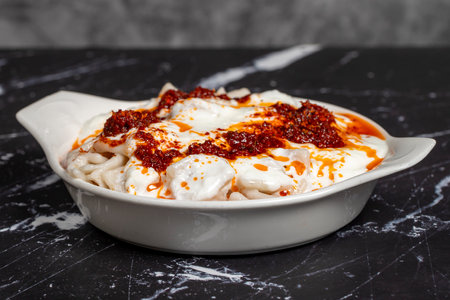 Ravioli with sauce and yogurt. Ravioli on a dark background. Turkish cuisine delicacies. close upの写真素材