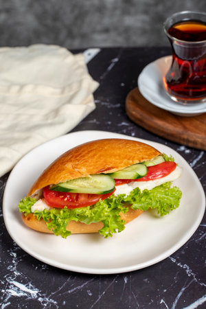 Sandwich with cheese, tomato, cucumber and lettuce. Delicious sandwich on dark backgroundの写真素材
