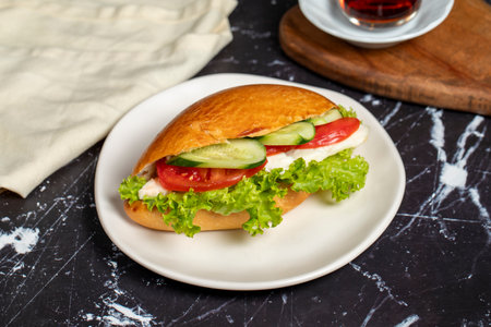 Sandwich with cheese, tomato, cucumber and lettuce. Delicious sandwich on dark backgroundの写真素材