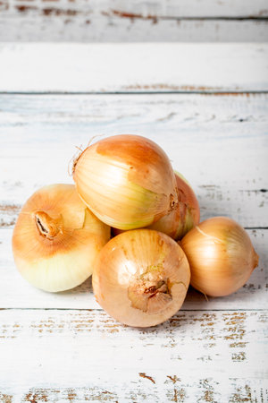 Onions on a white wood background. Fresh raw onion harvest season concept. Vegetables for a healthy dietの写真素材