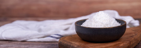 Coconut powder. Grounded coconut flakes on wood floor. Dark bowl of dessicated coconut. Copy space....