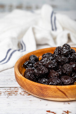 Black olives at wooden bowl. Olives on a white wood background. Mediterranean food. vegan food. close upの写真素材