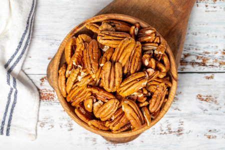 Pecan nut in wood bowl. Pecan nut on white wood background. top viewの写真素材