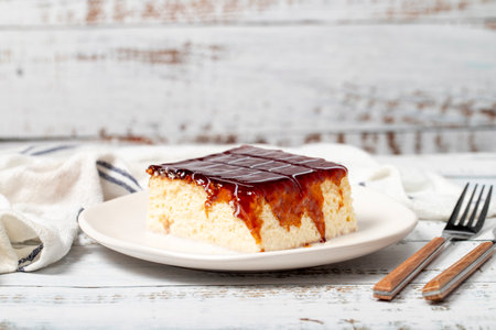 Tres leches cake. Slices of trilece cake with milk and caramel on a wooden background. patisserie...