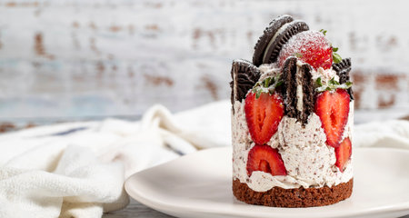 Strawberry and cookie cake. Fresh cake with cream and strawberries on a plate