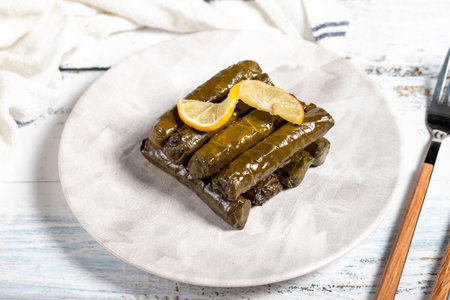 Stuffed grape leaves with olive oil. Turkish cuisine delicacies. Delicious stuffed grape leaves on a white backgroundの写真素材