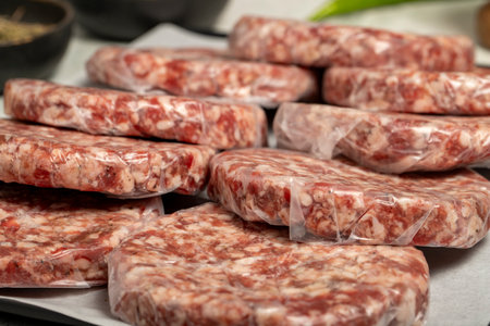 Raw hamburger Patty. Butcher products. Raw hamburger patties with gelatin on a stone backgroundの写真素材