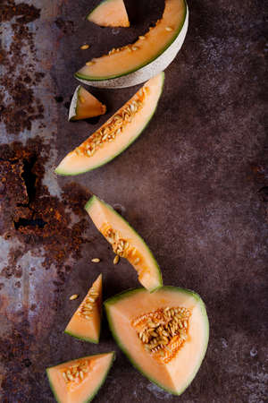 Melon slices in rusty metal background from the topの写真素材