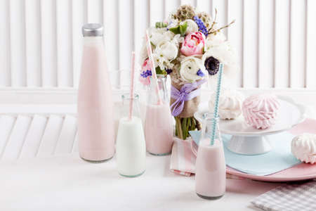 Four bottles of milkshakes, shutter with bouquet from pink tulips with violet ribbonの写真素材