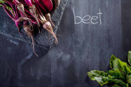 Bunch of beetroots on the stone and blackboard with chalk noteの写真素材