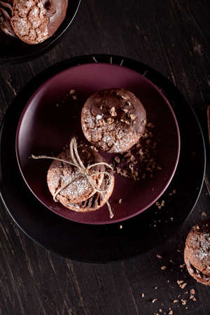 Italian maroni cookies with pieces of chocolate on old wooden background and plates, top viewの写真素材