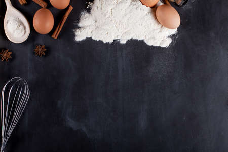 Ingredients like eggs, flour, cinnamon, anise, rolling pin, paper on blackboard