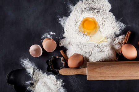 Ingredients like eggs, flour, cinnamon, anise, rolling pin, paper on blackboard