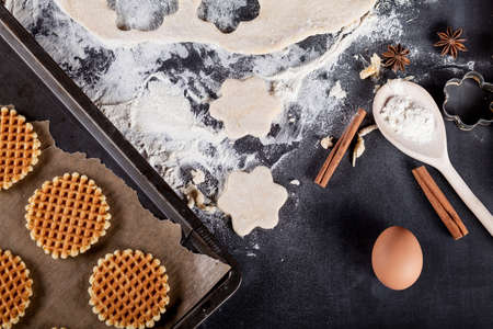 Cookie ingredients like eggs, flour, cinnamon, anise, rolling pin, paper on blackboard from the topの写真素材