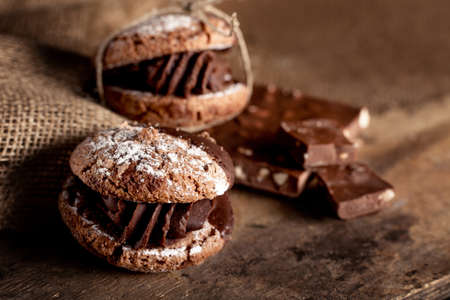 Italian maroni cookies with pieces of chocolate on old wooden backgroundの写真素材