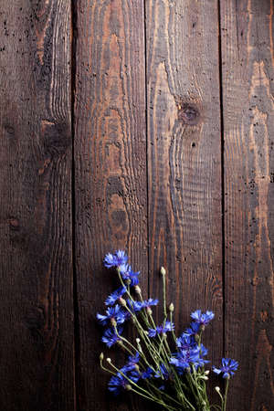 Blue cornflowers on old wood, flat layの写真素材