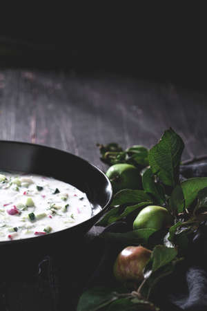 White garlic soup in black bowl on black, wooden tableの写真素材