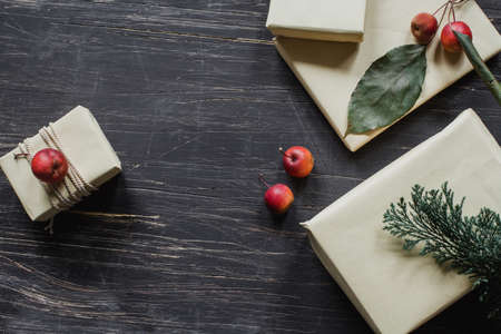 Christmas presents with apples and spruce on rustic, black tableの写真素材