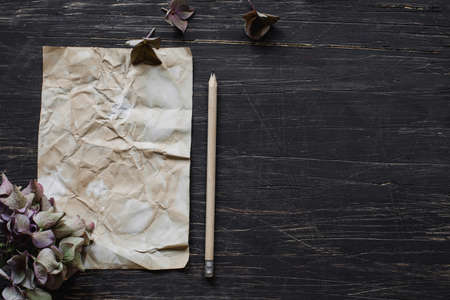 Paper on black table with hydrangea flowersの写真素材
