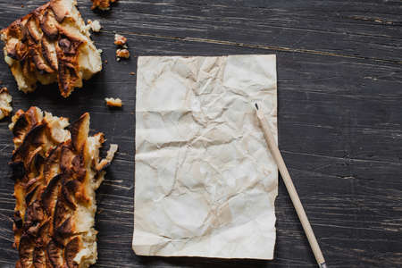Christmas tart with sheet of paper and pencil on black wooden table,flat layの写真素材