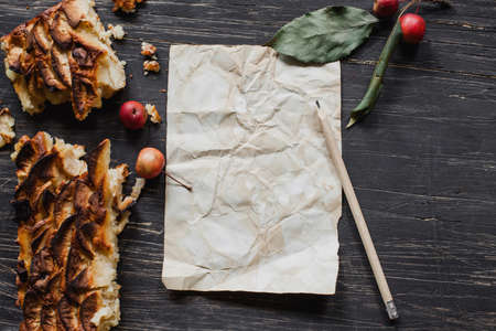 Christmas tart with sheet of paper and pencil on black wooden tableの写真素材