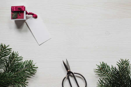 Small, elegant present with label on white table with spruce branches and scissorsの写真素材