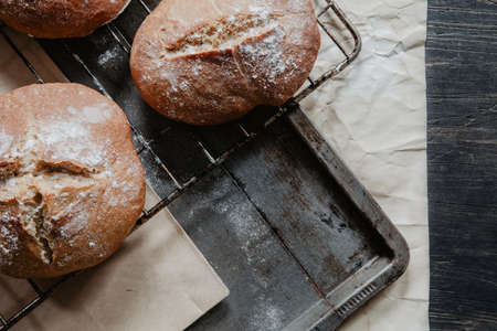 Freshly baked bread lying on a baking tray with flourの写真素材