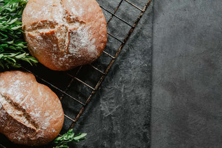 Homemade Easter bread on a cooling rack over old, blackboard background with boxwoodの写真素材