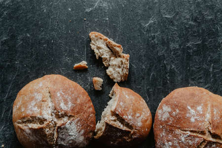 Homemade loaf of Irish soda bread with raisins on black stoneの写真素材
