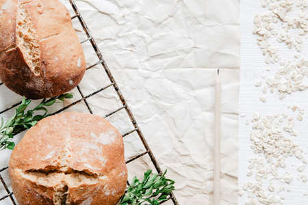Homemade rustic bread on cooling rack over wooden background with boxwoodの写真素材