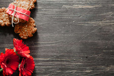 Anzac cookies with red flowers on a scratched wooden tableの写真素材