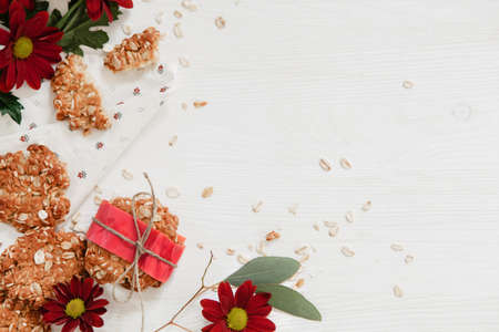 Vegan oat cookies on a white table with red flowers on the side
の写真素材