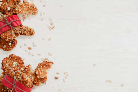 Healthy vegan oat cookies in red paper on the white wooden tableの写真素材