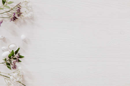 Easter decoration with little eggs, violet and white flowers on wooden tableの写真素材