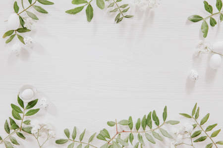 Flower frame with easter eggs and green leavesの写真素材
