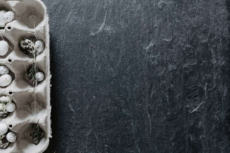 Easter table setting with egg box on black stoneの写真素材