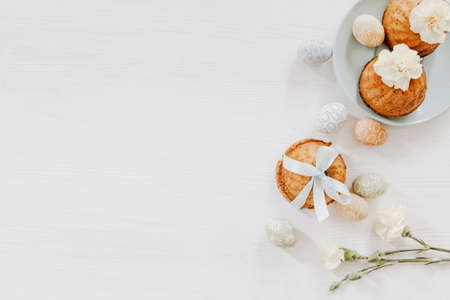 Simple, pastel decoration with cupcakes on plate and little colorful eggs with yellow gillyflowers の写真素材