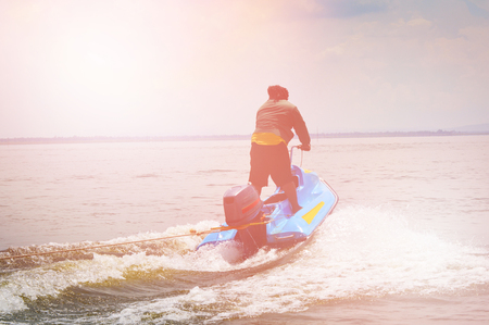 Silhouette of man jumps on the jetski above the water on the waveの写真素材