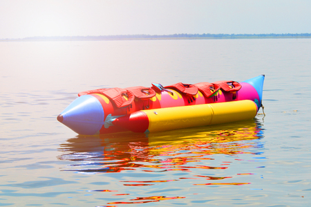 Banana Boat for fun / colorful of banana boat float on water surface in summer day - banana boat with life jacket on banana boat at the seaの写真素材